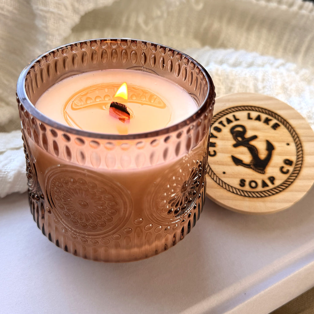 Pumpkin Praline soy candle burning with Crystal Lake Soap Co. wood lid